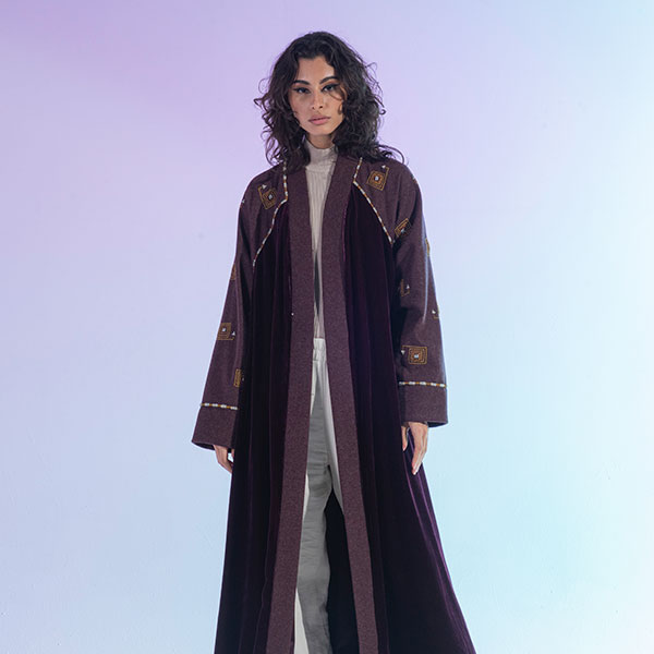 An abaya with a mixture of wool and velvet materials decorated with hand embroidery inspired by the Hijaz region