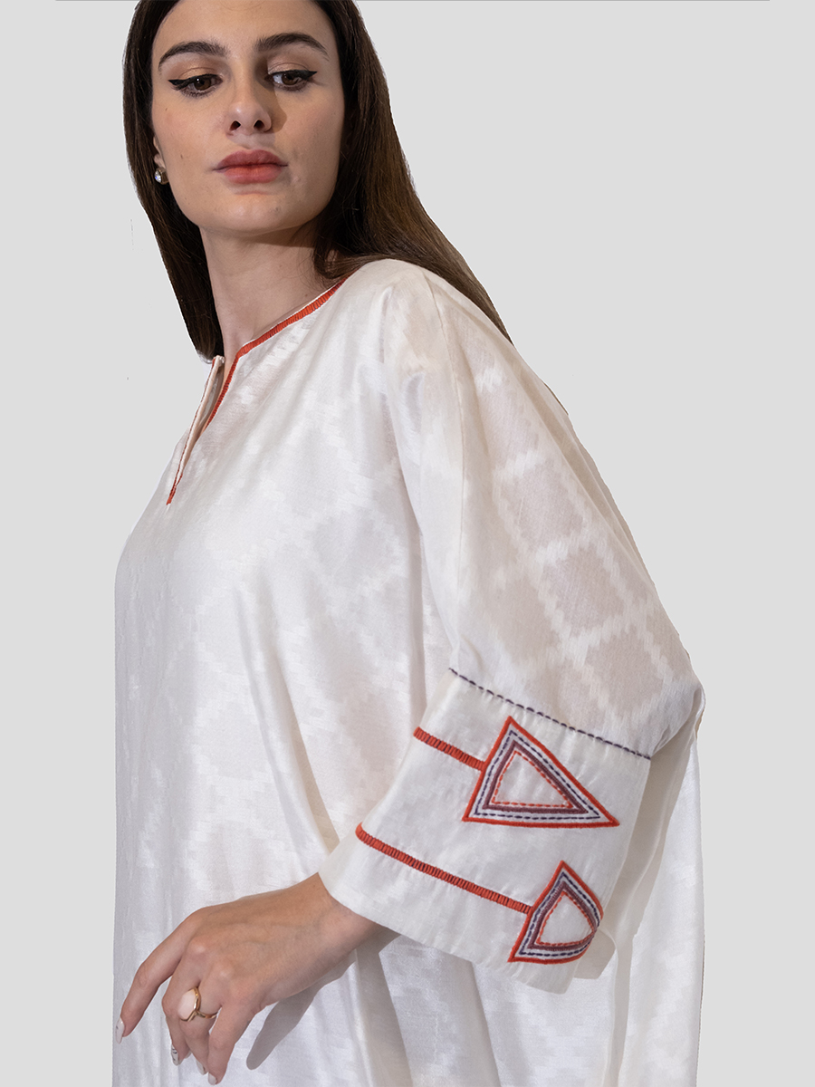 white dress with embroidery on sleeves