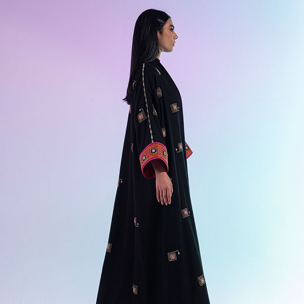 A hand-embroidered wool abaya with bright colors and patterns inspired by the Hijaz region